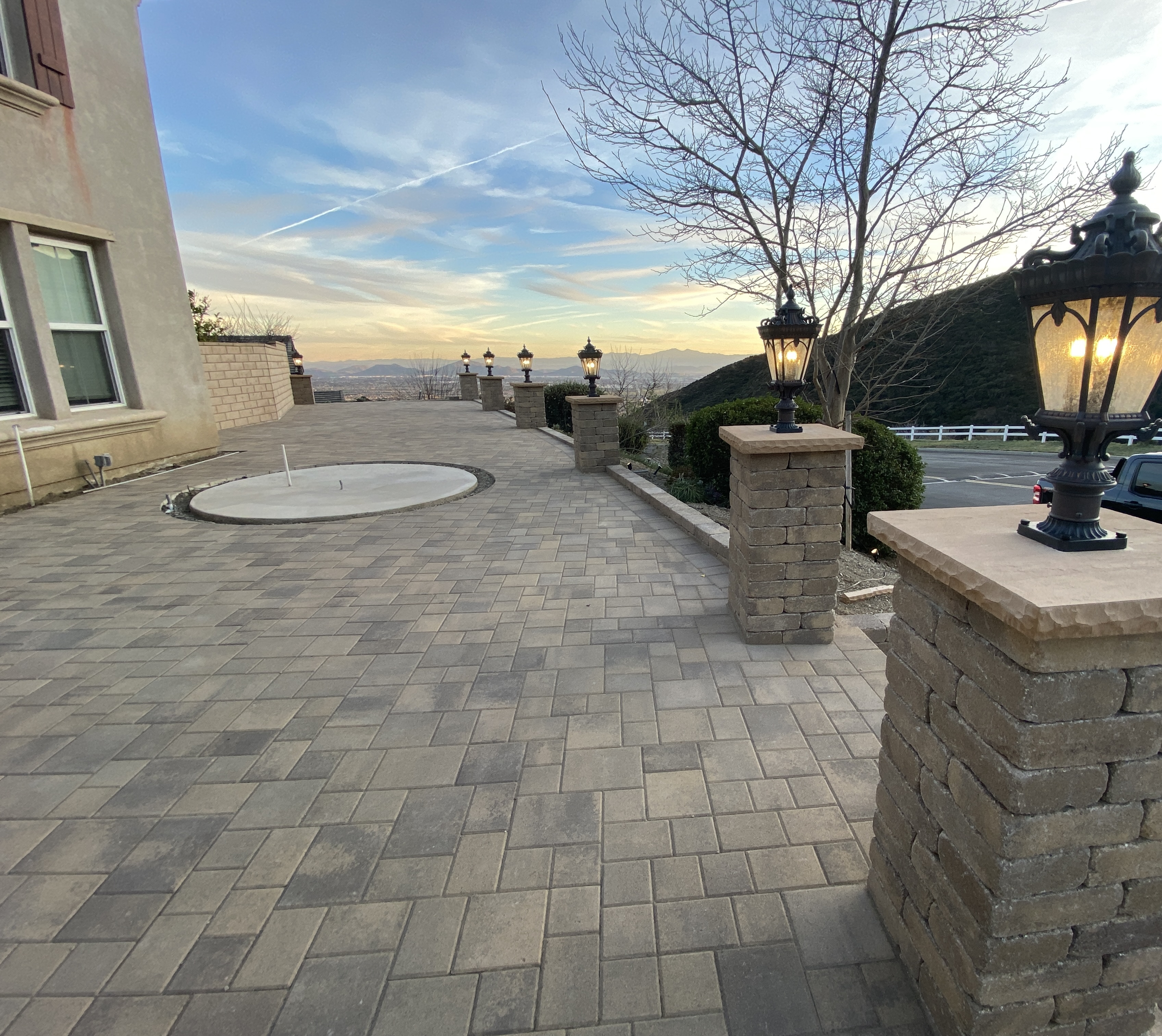 Expansive paver patio with lamp posts at golden hour