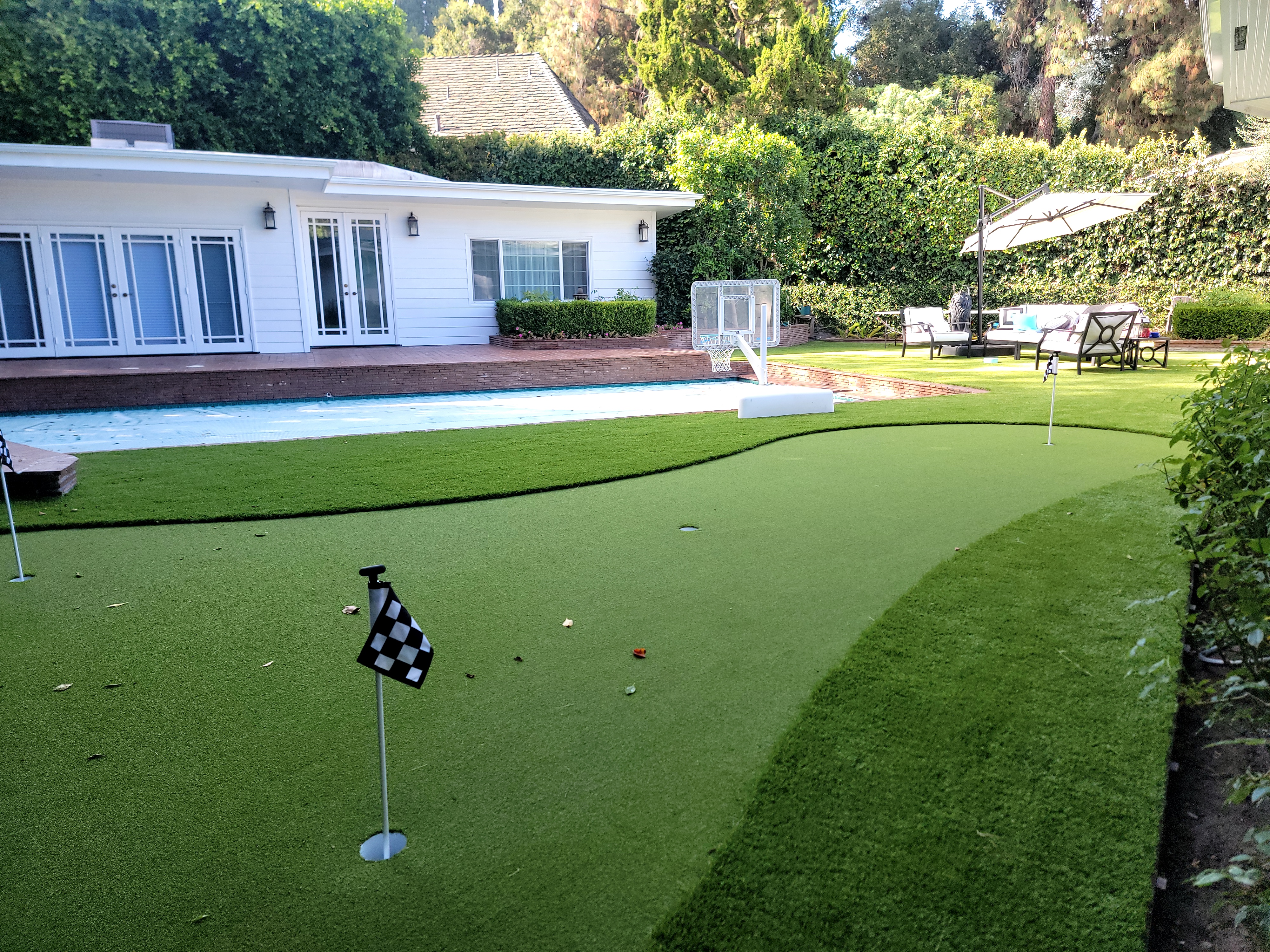 Backyard putting green next to pool
